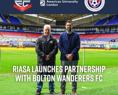 Two people stand in a stadium; text announces RIASA's partnership with Bolton Wanderers FC, alongside logos of the involved organizations.