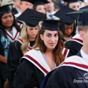 A group of people don graduation gowns and caps.