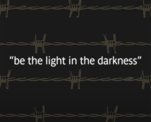 In this image, a person is encouraging others to be a source of hope and positivity in difficult times. Full Text: "be the light in the darkness"