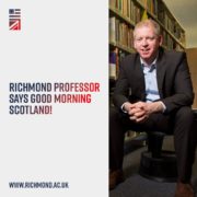 A person seated in a library, smiling at the camera, with text, "Richmond Professor says Good Morning Scotland!" and a website URL.