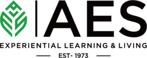 The image is a logo featuring the acronym "IAES" with a green leaf design above, and the tagline "EXPERIENTIAL LEARNING & LIVING" below, indicating environmental or educational focus, established in 1973.